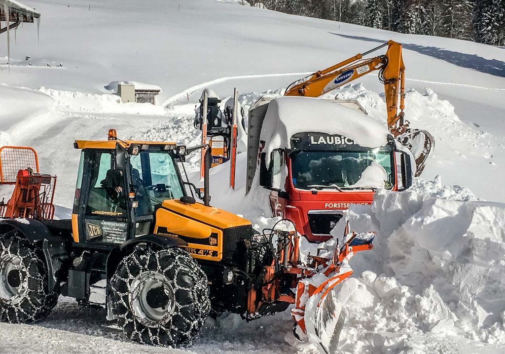 Schneeräumung mit JCB Fastrac, Holzlastwagen MAN, Kettenbagger